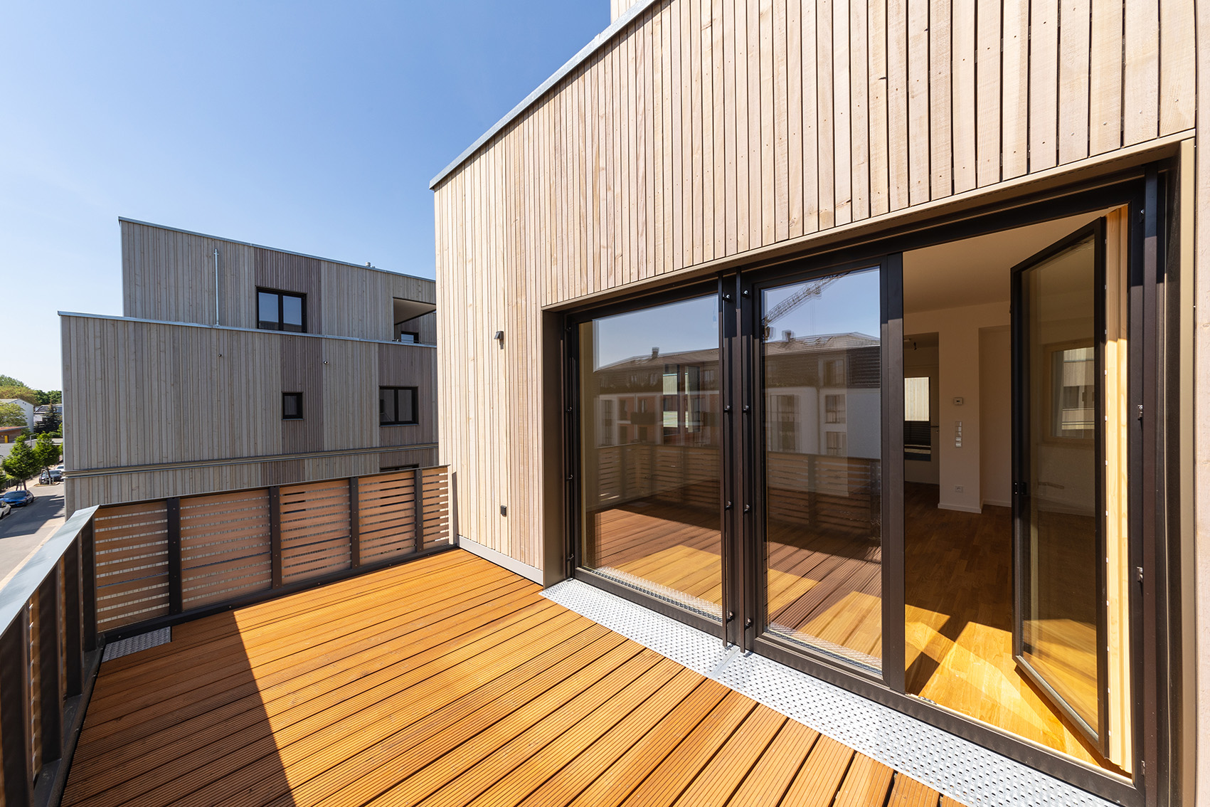 Holzbauprojekt BUWOG Lotsenhäuser im Berliner Quartier 52 Grad Nord mit Blick von einer Terrasse auf die Umgebung und in die Wohnung
