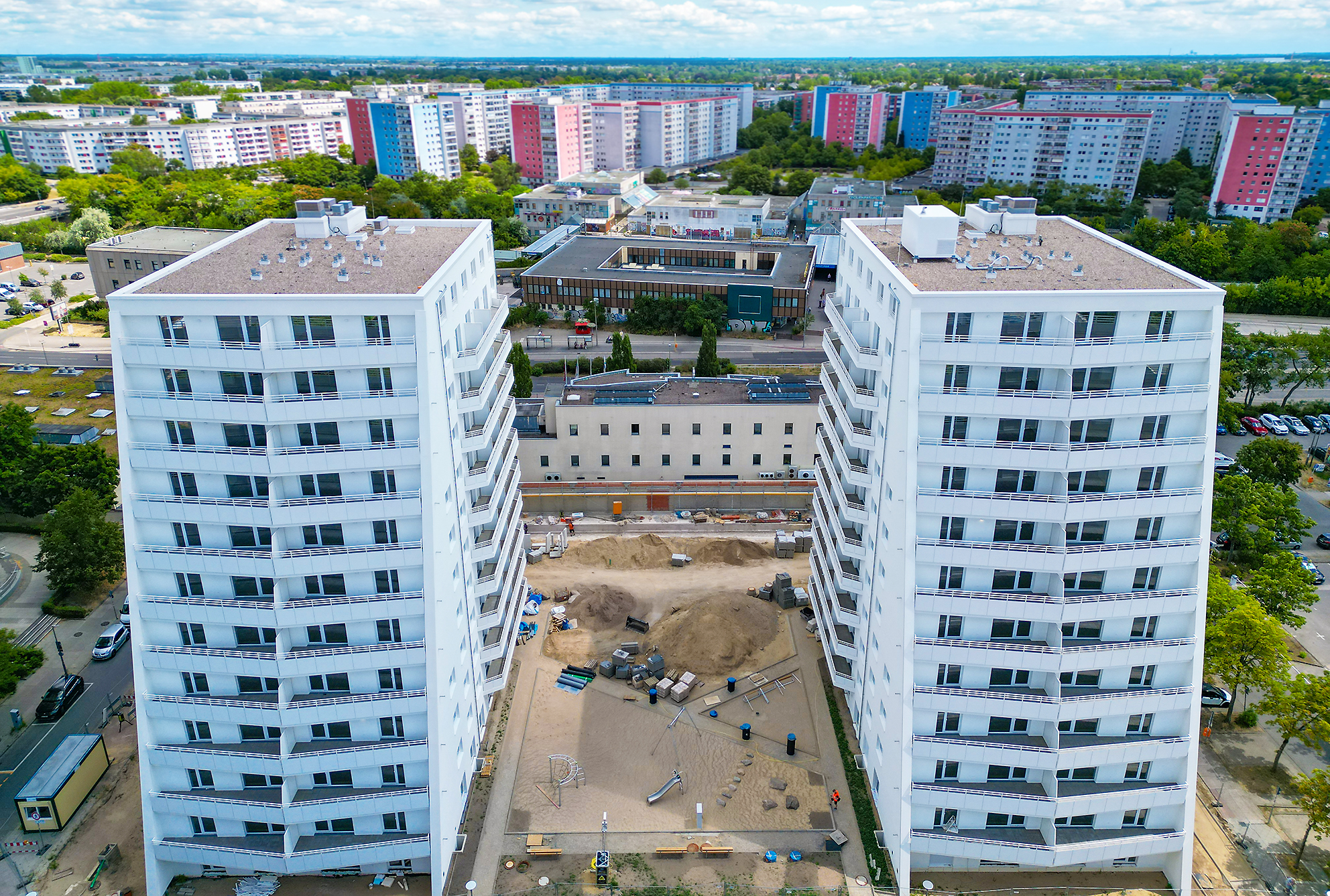 Zu sehen ist eine Drohnenaufnahme vom Projekt Ludwigsluster Straße 100 mit Blick frontal auf beide Hochhäuser.
