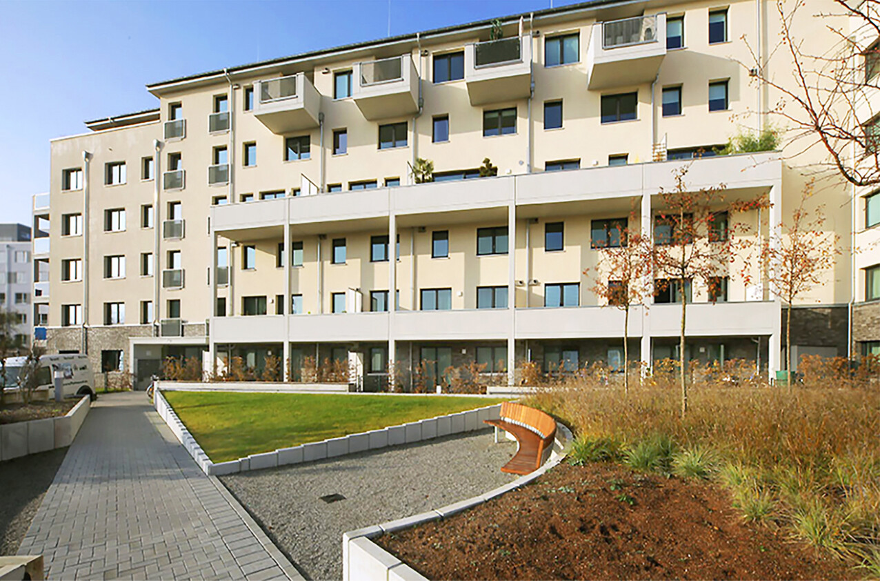Mit Blick vom Hof aus auf die Frontansicht und auf Baenke des BUWOG Neubauprojekts Saloë im Rhein-Main-Gebiet