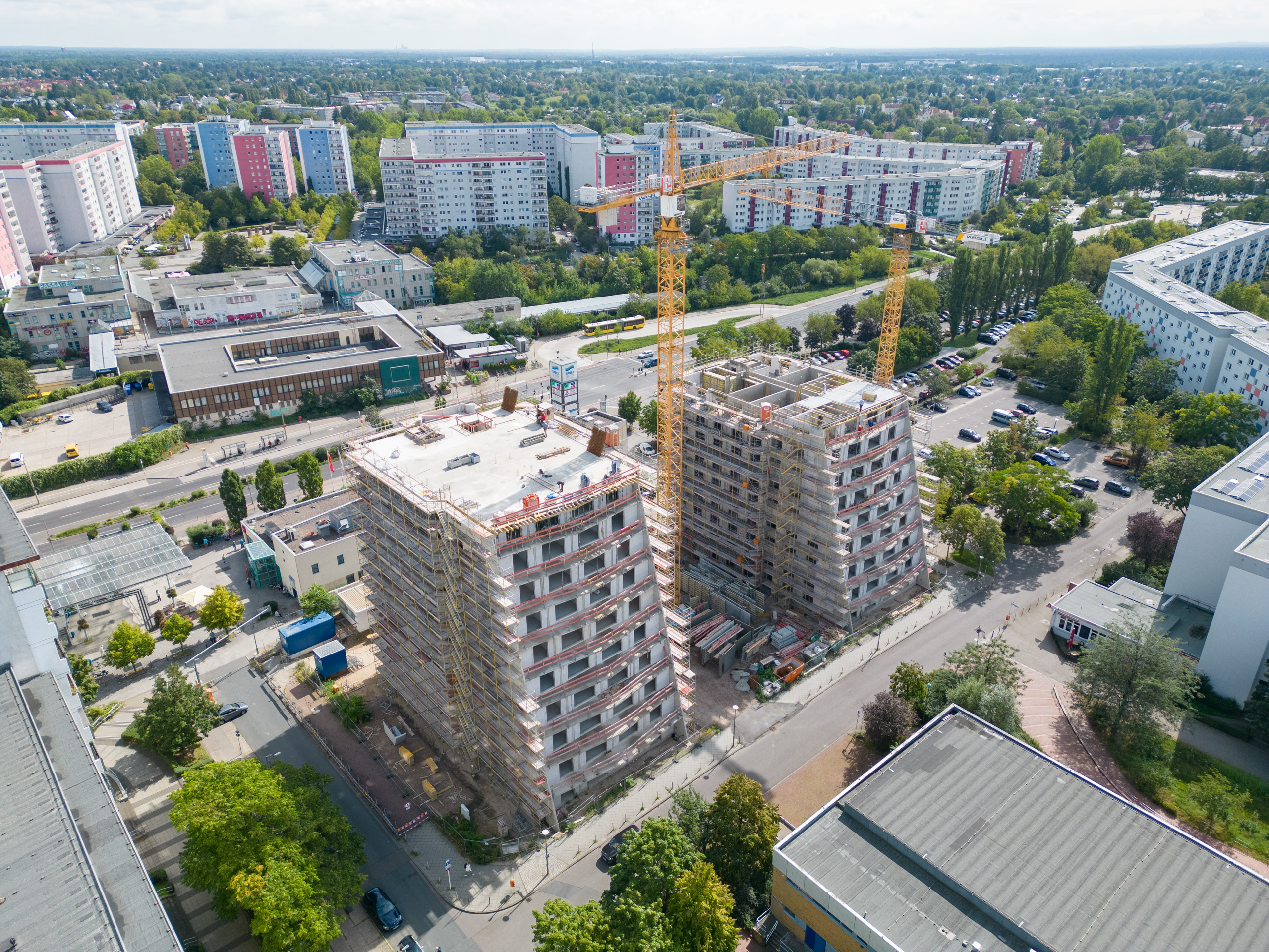 Zu sehen ist eine Drohnenaufnahme von Projekt Ludwigsluster Straße 100 mit Blick auf beide Häuser und auf die Front der Häuser. Beide sind noch mit Gerüst.