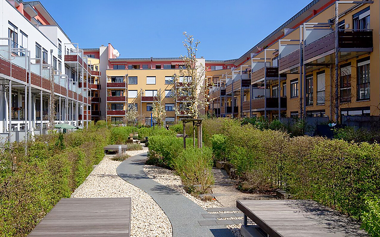 Mit Blick vom Hof aus auf die Begrünung und die Sitzmoeglichkeiten des BUWOG Neubauprojekts kukuun im Rhein-Main-Gebiet