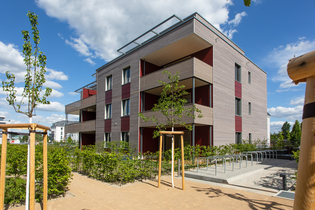Nachhaltige BUWOG Kompasshäuser in Holz-Hybrid-Bauweise in Berlin-Grünau im Quartier 52 Grad Nord mit Sicht auf ein Haus mit Hof