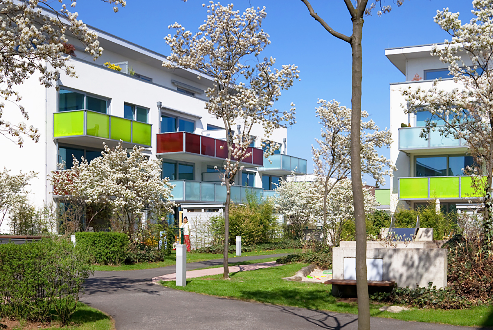 Mit Blick vom Hof und den Fußwegen aus auf mehrere Gebäude des BUWOG Neubauprojekts KiDONO im Rhein-Main-Gebiet