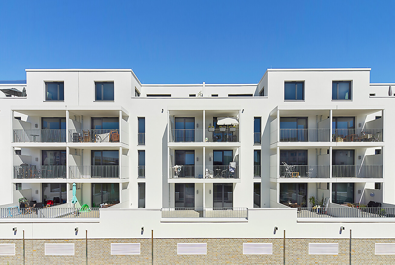 Mit Blick vom Hof aus auf die Frontansicht mit Balkonen und Terrassen im Erdgeschoss des BUWOG Neubauprojekts GROOVIN’ HIGH im Rhein-Main-Gebiet