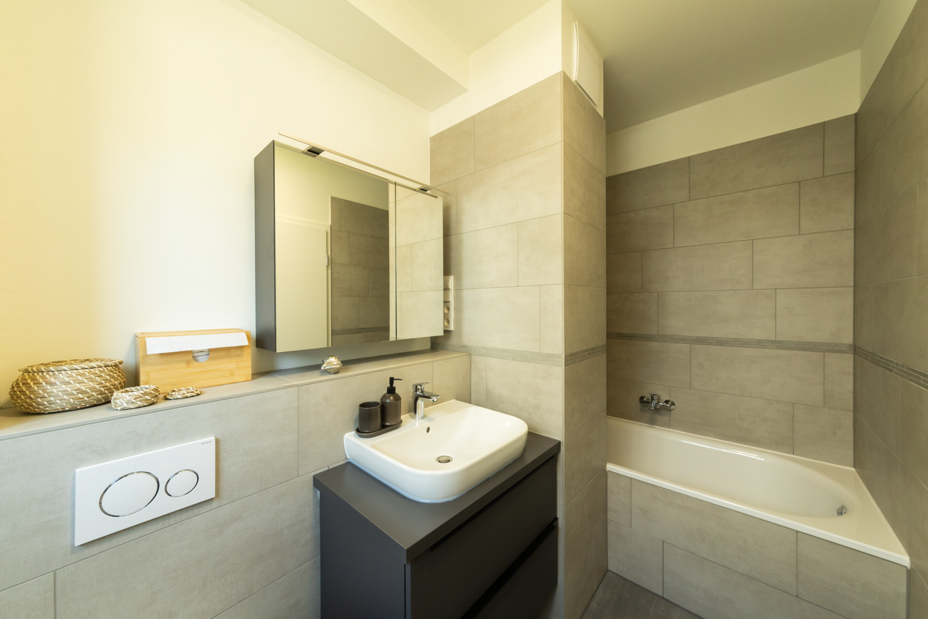 Badezimmer mit Badewanne und Waschtisch in BUWOG Havelgalerie