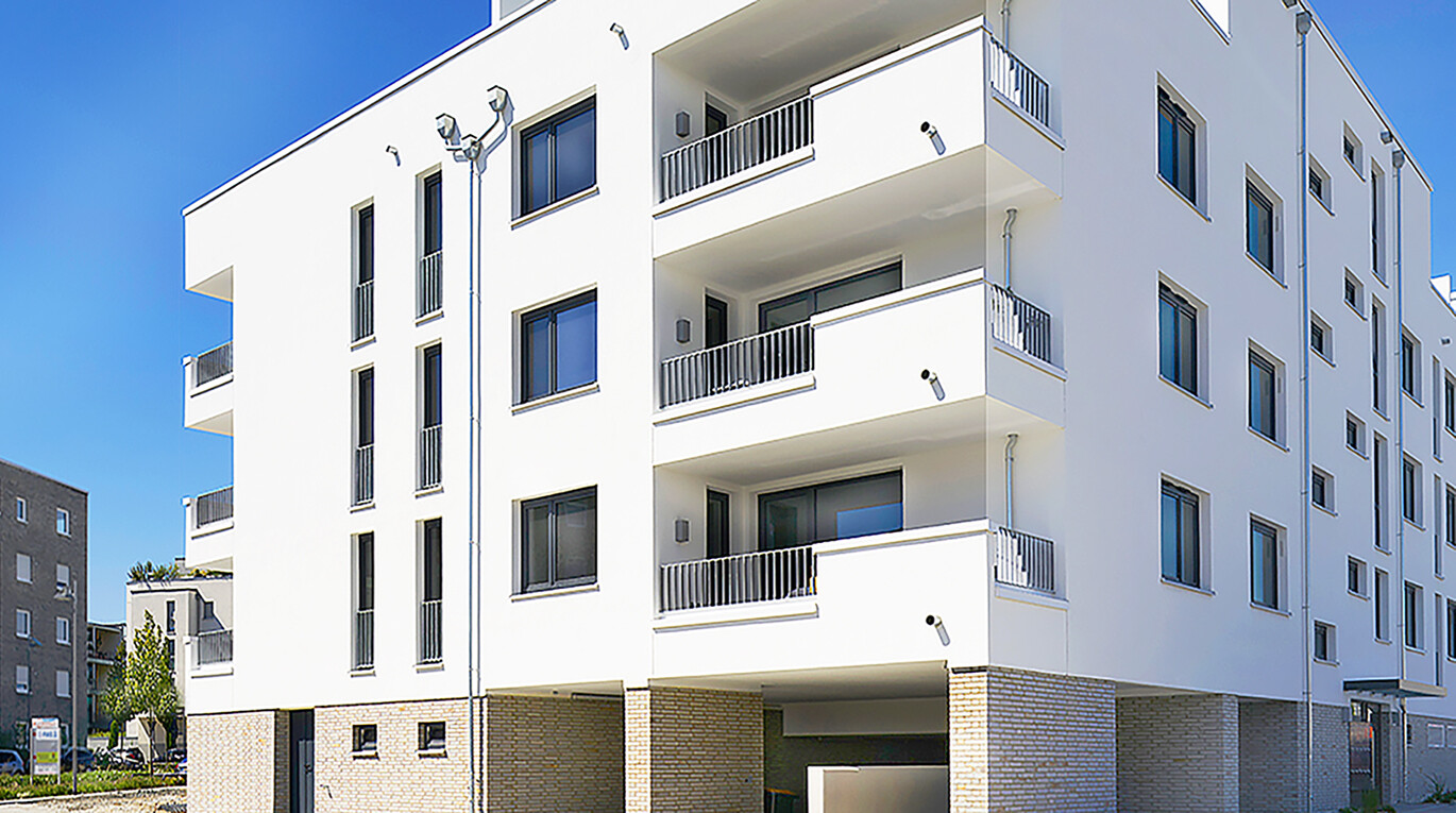 Mit Blick von der Straße aus auf die Seitenansicht mit Balkonen des BUWOG Neubauprojekts GROOVIN’ HIGH im Rhein-Main-Gebiet