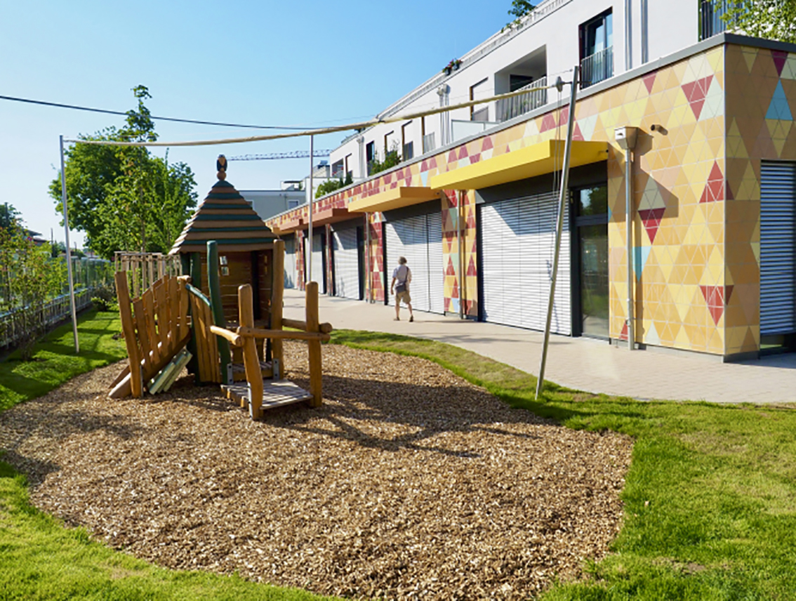 Zu sehen ist ein kleiner Spielplatz mit einen kleinen Grünanlage