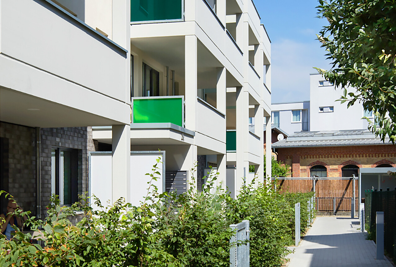 Mit Blick von der Seite und vom Hof aus auf die Hausansicht, Balkone und Fenster des BUWOG Neubauprojekts Saloë im Rhein-Main-Gebiet