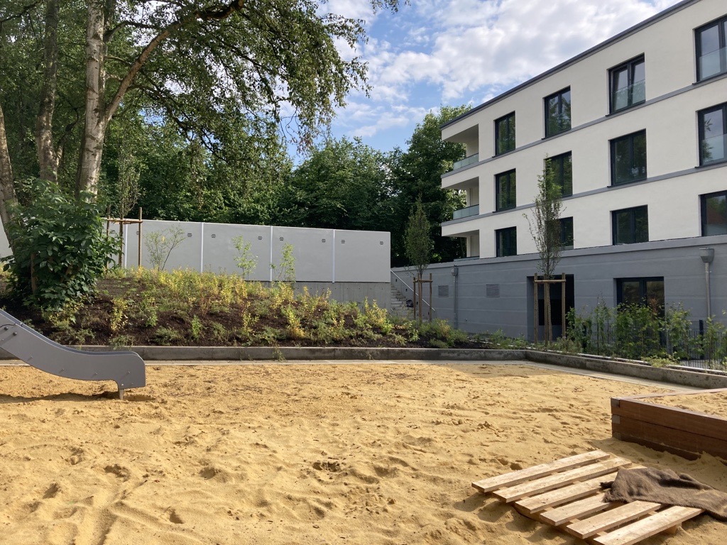Zu sehen ist der Spielplatz mit Rutsche und Sand vom Neubauprojekt in der Metzer Straße in Dortmund