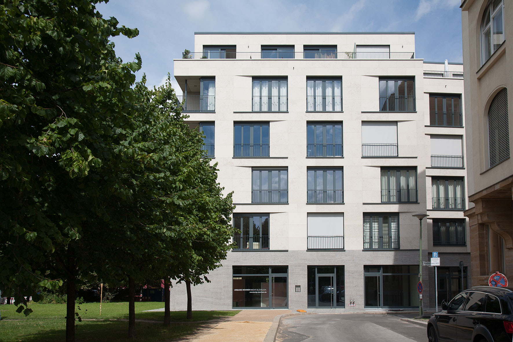 Mit Blick vom Hof aus auf die Frontansicht einer Fassade des Berliner BUWOG Neubauprojekts Humboldt Palais