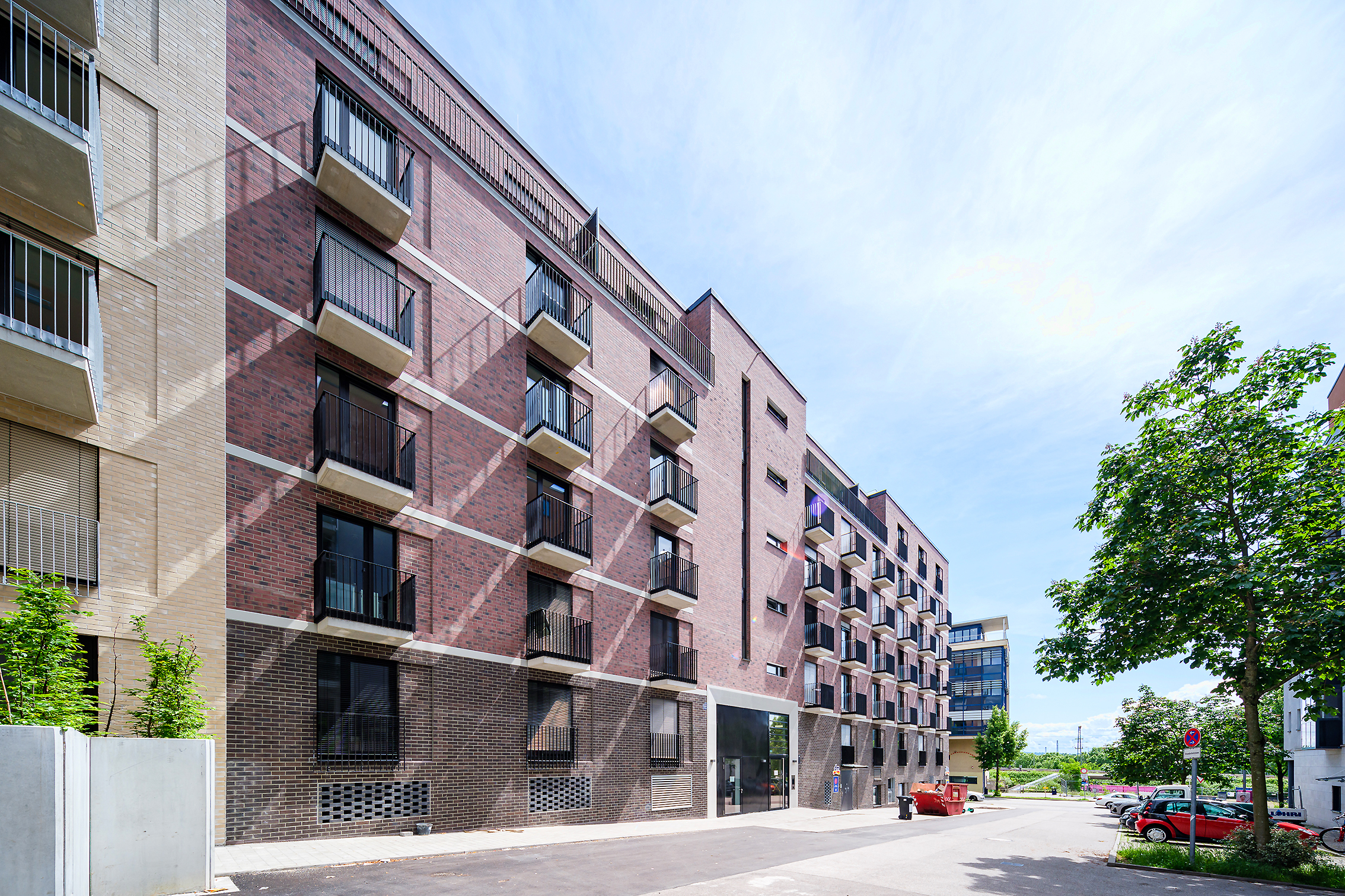Zu sehen ist ein Gebäude des Rosenstein Mitte Quartiers mit Blick seitlich von der Straße aus auf das braune Haus.
