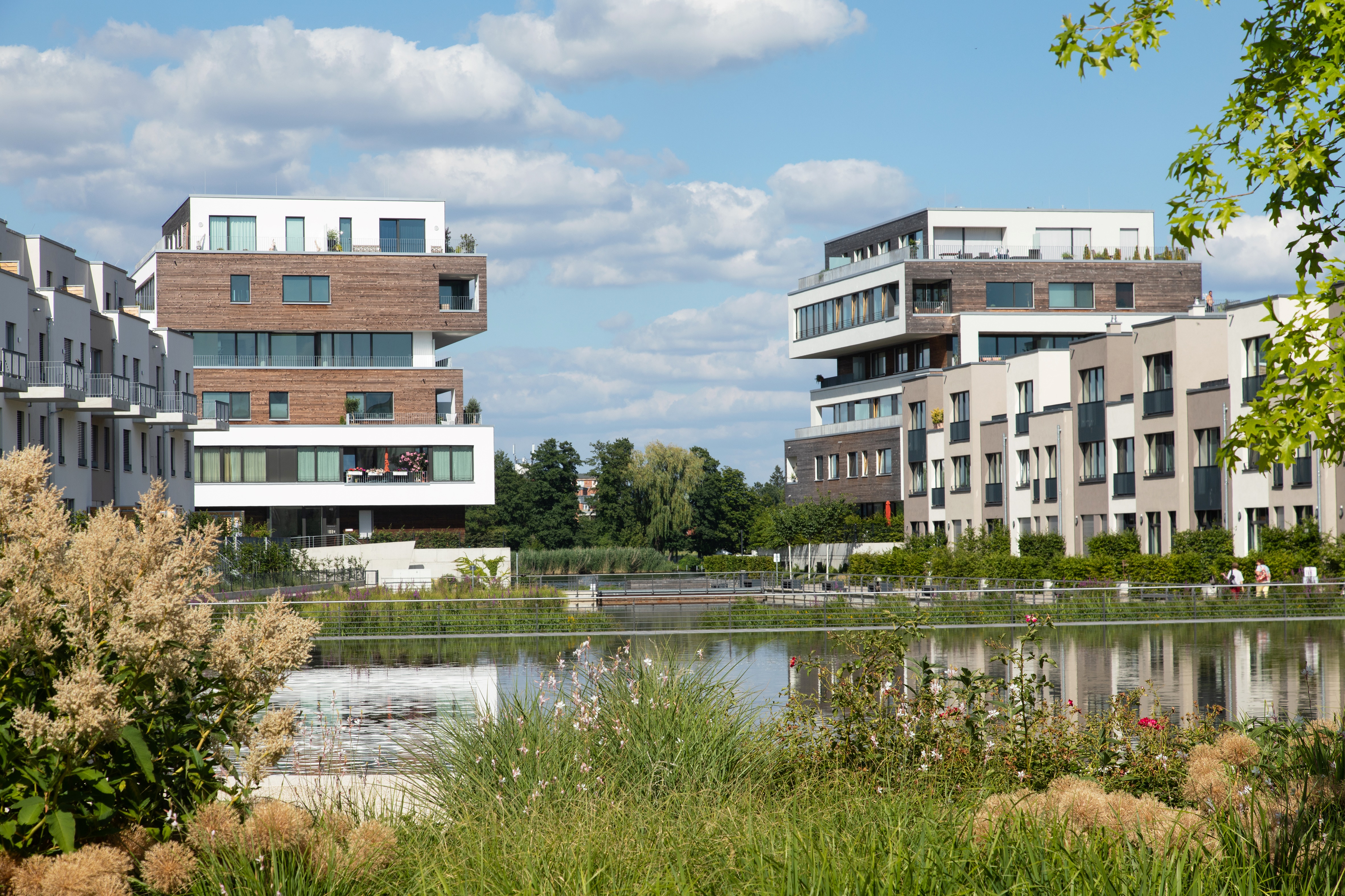 You can see 2 buildings in the background and water with green areas in the foreground.