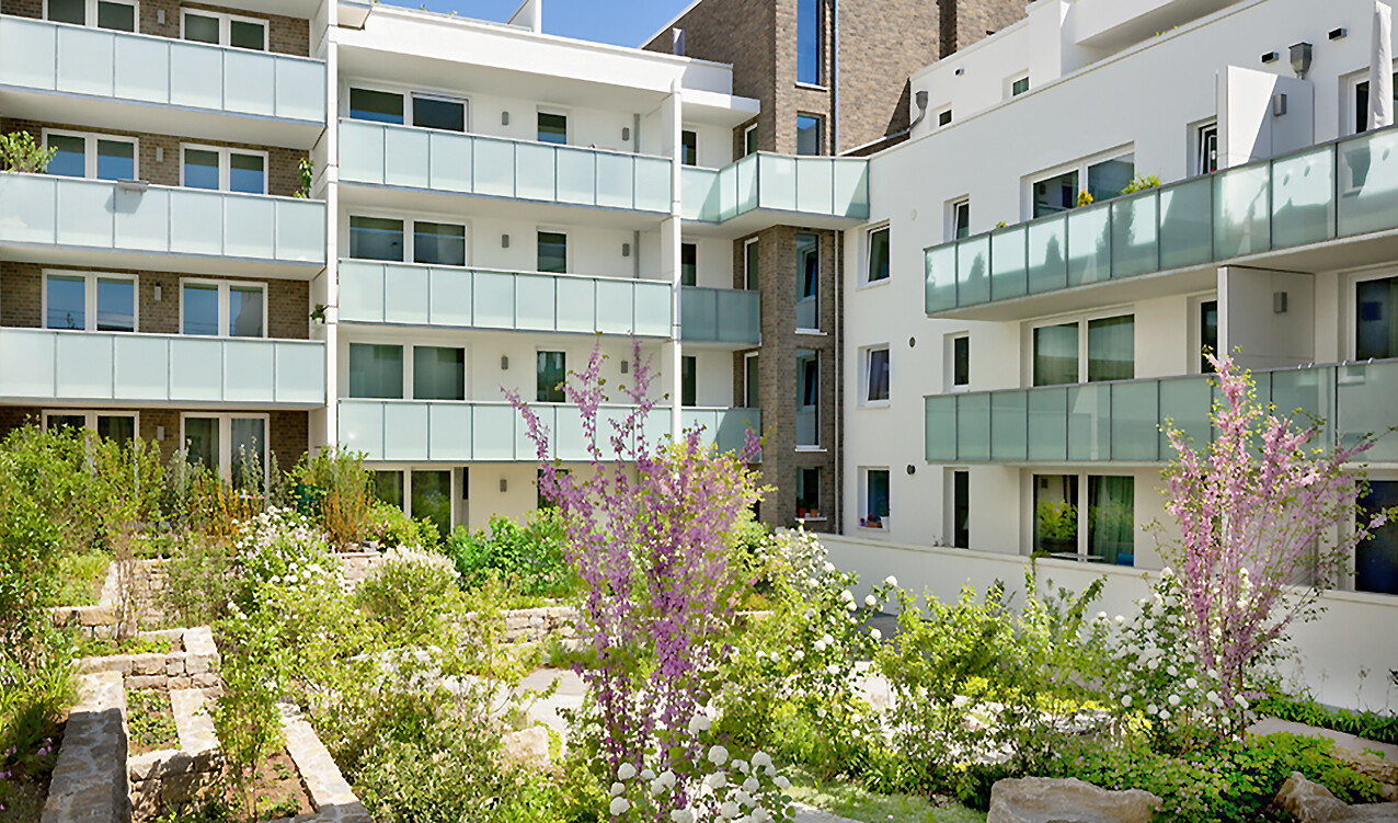 Mit Blick vom Hof aus auf die Frontansicht und auf die Begruenung des BUWOG Neubauprojekts feelin’ good im Rhein-Main-Gebiet