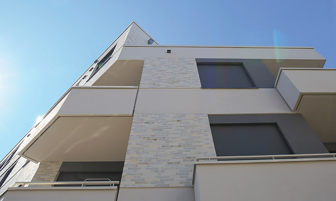Mit Blick von unten aus auf die Fassade eines Hauses des BUWOG Neubauprojekts Alegoré im Rhein-Main-Gebiet